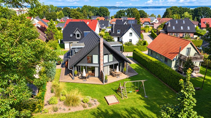 Aerial view of the Ahorneck holiday home with garden, playground and Lake Fleesensee in the background